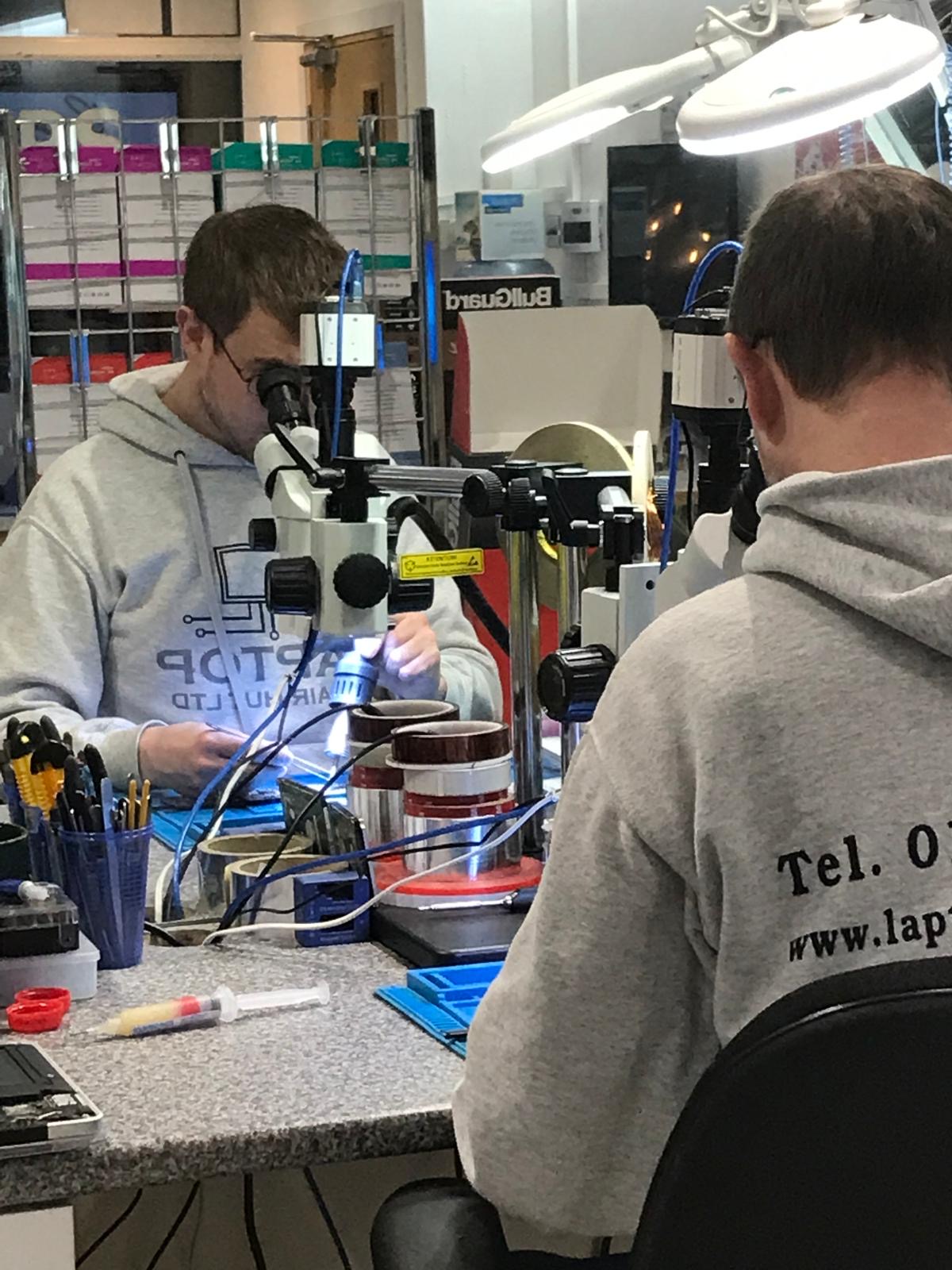 Stephen working under a microscope in the Laptop Repair Hut workshop